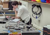 Shoshana Apple looking at laptop in a lab